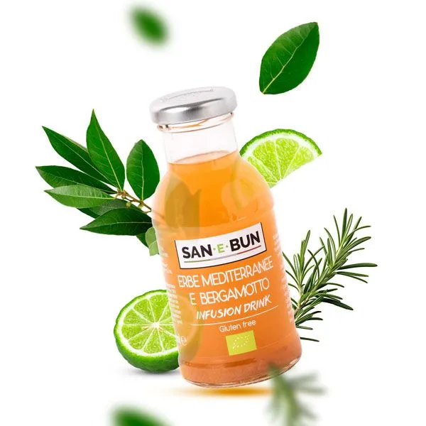 Napar z bergamotki w szklanej butelce. W tle limonka i zioła