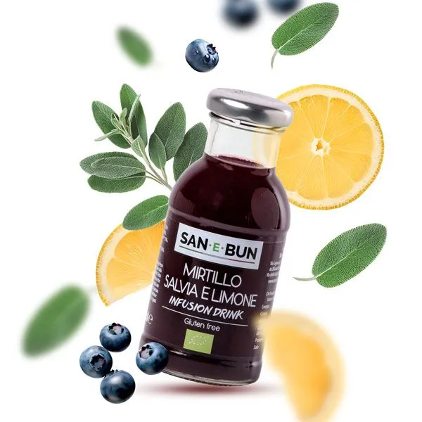 Organiczny napar z borówki, szałwii i cytryny w szklanej butelce. W tle borówki, cytryny i szałwia